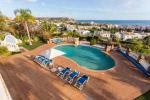 
a beach area with a pool, chairs, and tables at CoolHouses Algarve Luz, 5 bed villa & pool, Casa N in Luz
