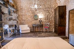 a bedroom with a bed and a stone wall at Luxury Cave Modica in Modica