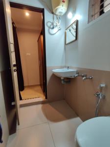 uma casa de banho com um lavatório, um WC e um espelho. em Vyavahar lodge em Udupi