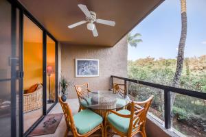 a patio with a table and chairs on a balcony at Kona Pacific C421 in Kailua-Kona