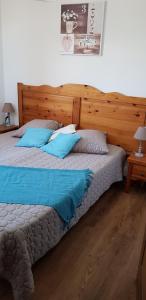 Un dormitorio con una cama grande con almohadas azules. en T2 Les Chardons avec Piscine Sauna et Hammam, en Valloire 29 fotos más