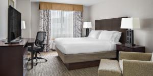 a hotel room with a bed and a desk and a television at Holiday Inn Express Grove City - Premium Outlet Mall by IHG in Grove City