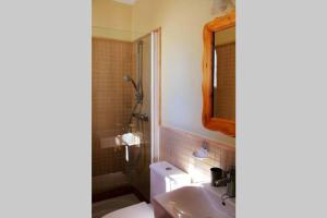 a bathroom with a sink and a toilet and a mirror at Casa mirando al mar, hermosas vistas. in Chipiona