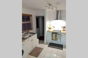 a kitchen with white cabinets and a sink at Hidden Gem in the Bay 10 Mins from WMC in Cardiff