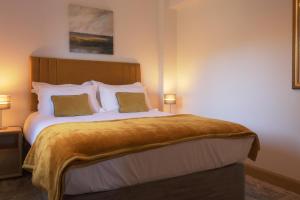 een slaapkamer met een groot bed met 2 kussens bij The Tack Room - Perfect for Two in Redlynch