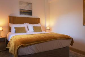 a bedroom with a large bed with two pillows at The Tack Room - Perfect for Two in Redlynch