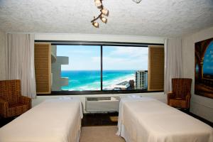 two beds in a room with a view of the ocean at Holiday Inn Resort Panama City Beach, an IHG Hotel in Panama City Beach