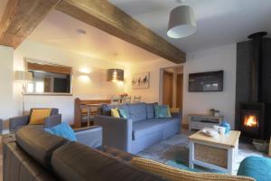 een woonkamer met een bank en een open haard bij The Tack Room - Perfect for Two in Redlynch