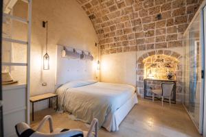 a bedroom with a bed and a brick wall at Villa Il Carrubo val di noto con piscina privata in Avola +77 photos