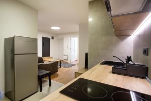 uma cozinha com um frigorífico e uma sala de estar em Apartment Ivy em Belgrado
