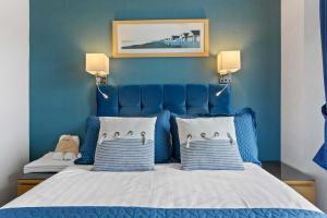 a blue bedroom with a bed with two pillows at The Ashleigh in Paignton