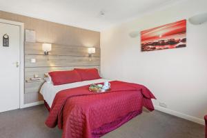 a bedroom with a bed with a red blanket at The Ashleigh in Paignton
