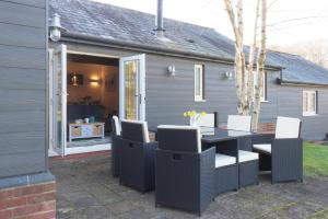 een patio met een tafel en stoelen voor een huis bij The Tack Room - Perfect for Two in Redlynch
