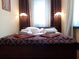 a bedroom with a bed with two towels on it at Resort Kasprowy Wierch in Zakopane