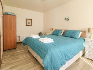 - une chambre dotée d'un grand lit avec des draps bleus dans l'établissement Shamrock, à Selby