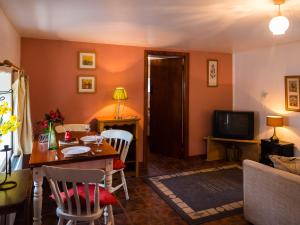 a living room with a table and a television at The Stable in Fethard on Sea