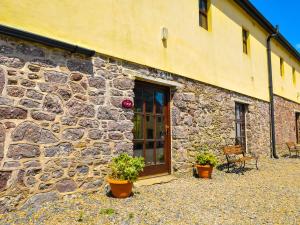a stone building with two potted plants in front of it at The Barn in Fethard on Sea