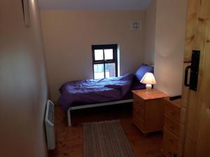 a small bedroom with a bed and a window at The Barn in Fethard on Sea