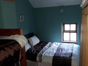 a bedroom with a bed and a window at The Barn in Fethard on Sea