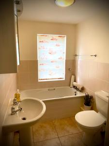 a bathroom with a tub and a sink and a toilet at Peaceful 2 bedroom granite country dower house in La Villaise