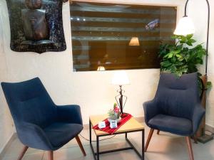 two blue chairs and a table in a room at Hotel Sagarnaga in La Paz