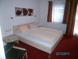 a bedroom with a white bed in a room at Gästehaus Hirschenhof in Sölden