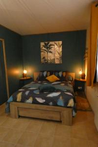 a bedroom with a bed with a blue wall at Gîte L'EAU VIVE in Noyers