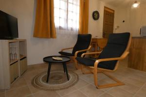 Noyers的住宿－Gîte L'EAU VIVE，客厅配有两把椅子和一张桌子