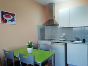 une cuisine avec une table et des chaises vertes dans l'établissement Villa Juan, à L'Eucaliptus 12 autres photos