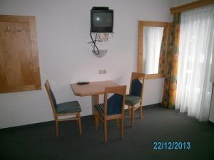 a room with a table and two chairs and a tv at Gästehaus Hirschenhof in Sölden