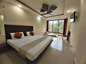 a bedroom with a large bed and a large window at Swastic Hotel at Calangute GOA in Calangute