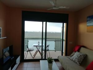 d'un salon avec un canapé et d'un balcon avec une table. dans l'établissement Villa Juan, à L'Eucaliptus