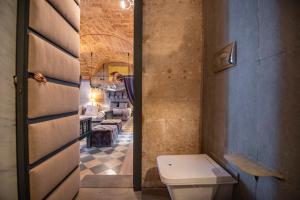 ein Badezimmer mit WC und ein Wohnzimmer in der Unterkunft Maniace Suites in Syrakus
