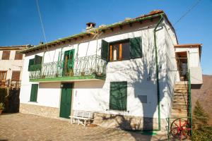 uma casa branca com uma varanda e uma escadaria em Rondinaio em Tereglio