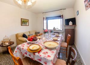 een eetkamer met een tafel en stoelen en een bank bij Rondinaio in Tereglio