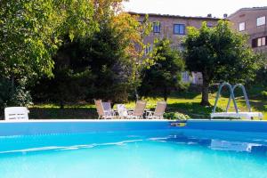 a swimming pool with two chairs and a table at Rondinaio in Tereglio