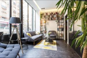 a living room with a couch and chairs and a table at Atypik Hotel in Clichy