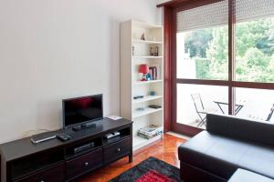 sala de estar con ventana grande y TV en O´Porto Torrinha Flat, en Oporto