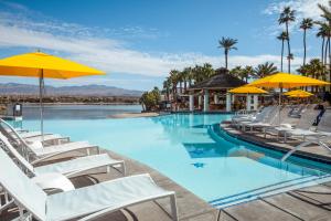 a large swimming pool with chairs and umbrellas at The Nautical Beachfront Resort in Lake Havasu City