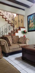 a living room with a couch and a staircase at CASA DE HUESPEDES CASA BONITA in La Lima