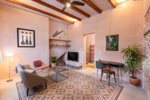 een woonkamer met een tv en een tafel en stoelen bij Casa Emiliana in Rhodos-stad
