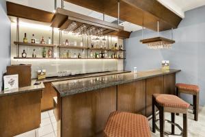 a bar in a restaurant with two stools at Hotel Aeropuerto Los Cabos in San José del Cabo