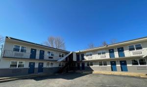 un edificio de apartamentos con puertas azules y aparcamiento en Tinton Falls NJ Neptune en Tinton Falls