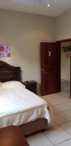 1 dormitorio con 1 cama y armario de madera en CASA DE HUESPEDES CASA BONITA, en La Lima