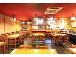 富士宮市にあるFujinomiya Green Hotel - Vacation STAY 19036vの木製のテーブルと椅子が置かれた空のレストラン +18枚の写真
