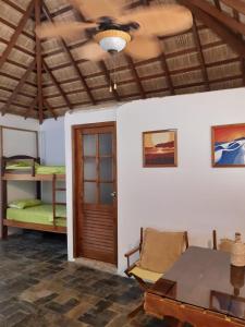 a room with a table and a room with bunk beds at Muyuyo Lodge in Ayangue