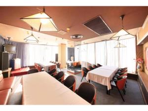 a dining room with tables and chairs and windows at Fujinomiya Green Hotel - Vacation STAY 19015v in Fujinomiya
