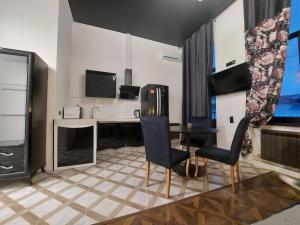 a living room with a table and a kitchen at In the heart of the city in Kharkiv