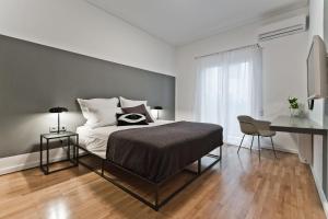 a bedroom with a bed and a desk in it at BAG- Boutique Apartment Grey - Hilton Area in Athens