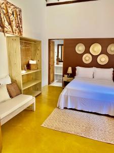 a bedroom with a bed and a bench in a room at Casas e apartamentos da Ilda in Trancoso